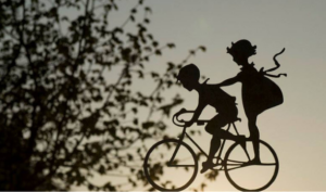 En pojke och en flicka på samma cykel